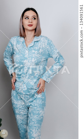 Full-length shot of a woman posing in a simple dark gray set with her arms raise Full-length shot of a woman posing in a simple dark gray set with her arms raise 134091561