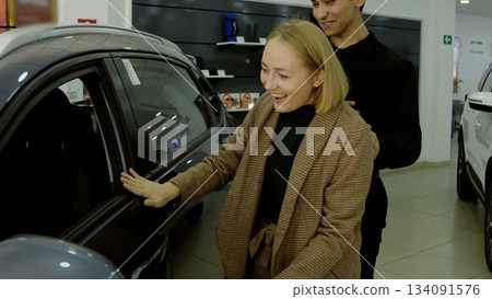 Female client examining car specifications document in the showroom Female client examining car specifications document in the showroom 134091576