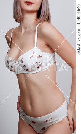 Female model posing in white lace and subtle floral print lingerie Female model posing in white lace and subtle floral print lingerie 134091646