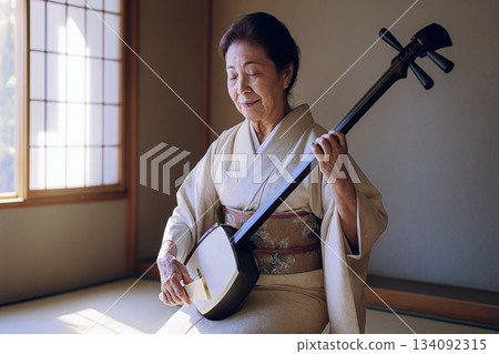 Senior woman playing the shamisen Senior woman playing the shamisen 134092315