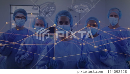 In hospital, medical team in scrubs and masks with image of network connections In hospital, medical team in scrubs and masks with image of network connections 134092528