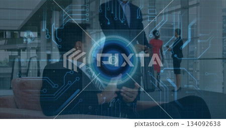 Collaborating team manipulating holographic interface in modern corporate lobby, with tablet 134092638