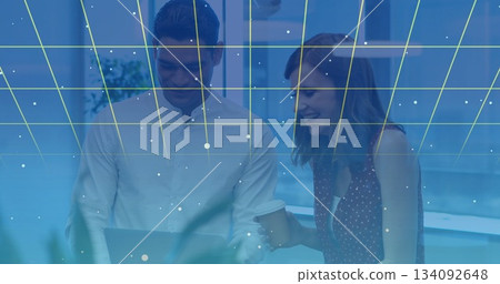 Collaborating colleagues using laptop with digital grid and data points overlay Collaborating colleagues using laptop with digital grid and data points overlay 134092648