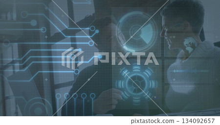 Discussing professionals in business attire analyzing holographic circuit display panels at desk 134092657
