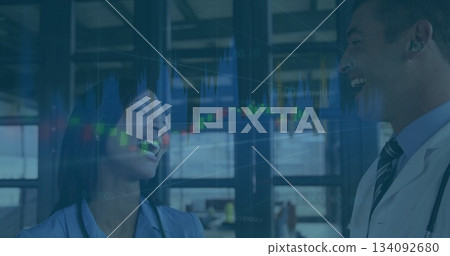 Laughing business professionals with stock market data image in office setting Laughing business professionals with stock market data image in office setting 134092680