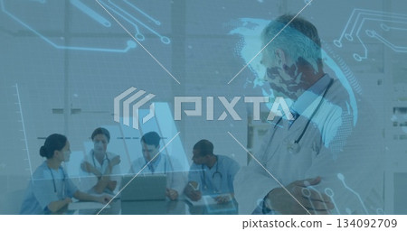 Standing senior Dr observing team collaborating at table with laptop in hospital room, copy space Standing senior Dr observing team collaborating at table with laptop in hospital room, copy space 134092709