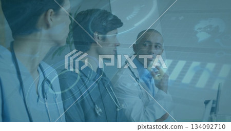 Three doctors wearing white lab coats and stethoscopes studying data on digital screen in hospital 134092710