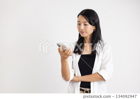 A woman smiling with a smartphone 134092947
