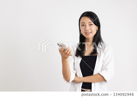 A woman smiling with a smartphone 134092948
