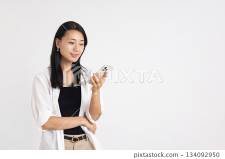 A woman smiling with a smartphone A woman smiling with a smartphone 134092950