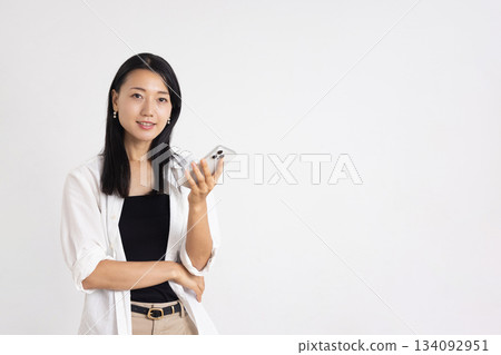 A woman smiling with a smartphone 134092951