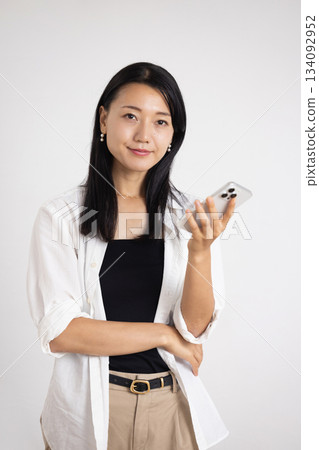 A woman smiling with a smartphone 134092952