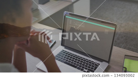 Leaning woman viewing laptop terminal in office, with smartphone and green mesh pouch, copy space Leaning woman viewing laptop terminal in office, with smartphone and green mesh pouch, copy space 134093002