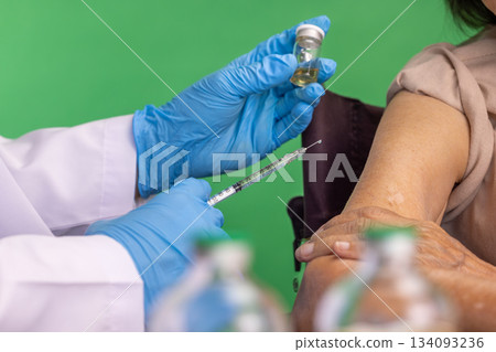 Chroma key, nurse doing vaccine injection to senior woman. Chroma key, nurse doing vaccine injection to senior woman. 134093236