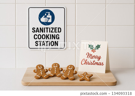Safe and sanitized cooking station for festive Christmas baking. Cheerful gingerbread cookie on board with holiday card, representing happy and clean hygiene concept 134093318