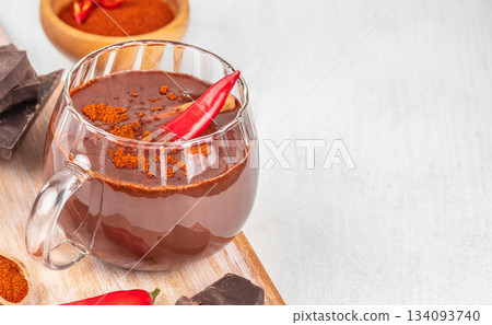 Spicy hot chocolate with chili pepper in glass cup on light background with copy space, creative winter drink concept 134093740