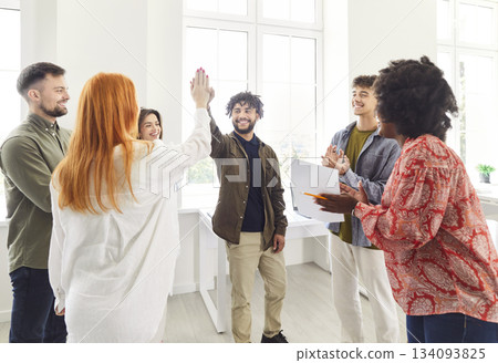 Happy Colleagues Celebrating Success With High Fives During Office Meeting 134093825