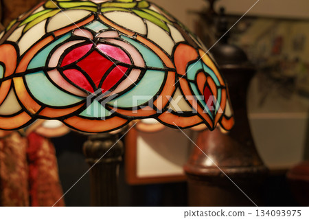 Close-up of the colorful pattern of a stained glass lampshade made of connected colored glass Close-up of the colorful pattern of a stained glass lampshade made of connected colored glass 134093975