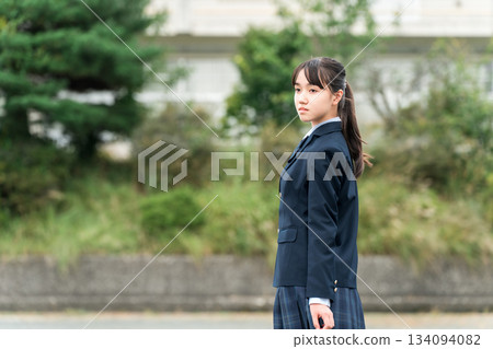 Junior high school, high school, and elementary school students in uniform standing in front of the school building 134094082