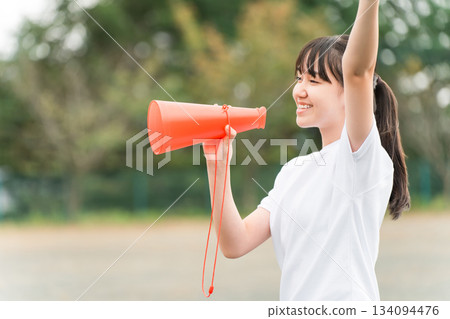 Junior high school, high school, and elementary school girls in gym clothes cheering with megaphones 134094476