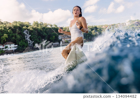 Surfer on surfboard during surfing. Surfer woman and ocean wave Surfer on surfboard during surfing. Surfer woman and ocean wave 134094482