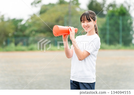 Junior high school, high school, and elementary school girls in gym clothes cheering with megaphones 134094555