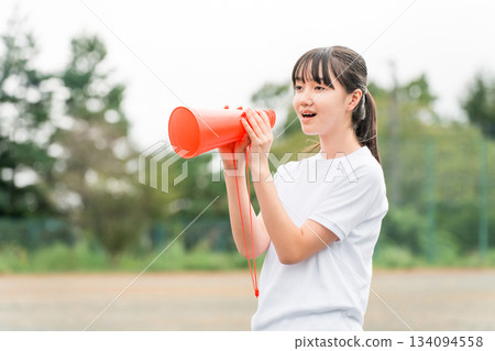 Junior high school, high school, and elementary school girls in gym clothes cheering with megaphones Junior high school, high school, and elementary school girls in gym clothes cheering with megaphones 134094558