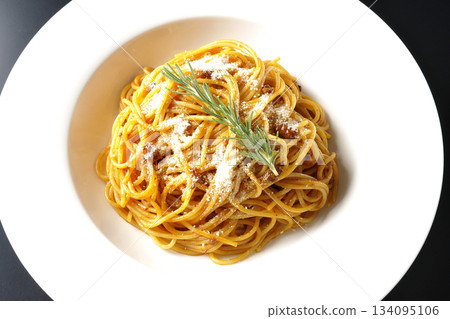 Spaghetti meat sauce with grated cheese and rosemary photographed against a black background Spaghetti meat sauce with grated cheese and rosemary photographed against a black background 134095106