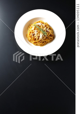 義大利麵肉醬配碎起司和迷迭香，以黑色背景拍攝。 134095111