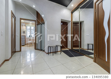Spacious Hallway Interior with Arch and Mirrored Wardrobe 134095380
