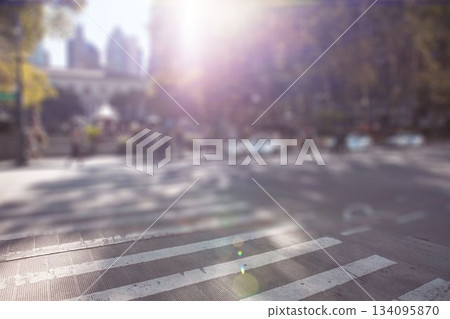 Zebra-striped crosswalk is stretching across sunlit city street with lens flare in flat design 134095870