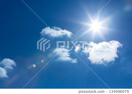 Sun is shining in flat design deep blue sky, with fluffy clouds and vibrant lens flare 134096079