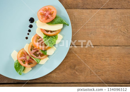 Fresh salad in plate on wooden table 134096312