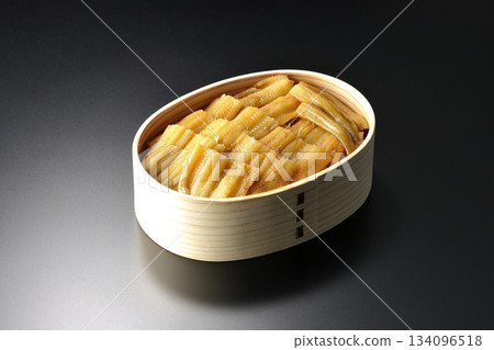 一個盛有煮熟康吉鰻的便當盒,在黑色背景下拍攝的照片。 一個盛有煮熟康吉鰻的便當盒,在黑色背景下拍攝的照片。 134096518