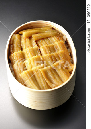 一個盛有煮熟康吉鰻的便當盒,在黑色背景下拍攝的照片。 一個盛有煮熟康吉鰻的便當盒,在黑色背景下拍攝的照片。 134096560