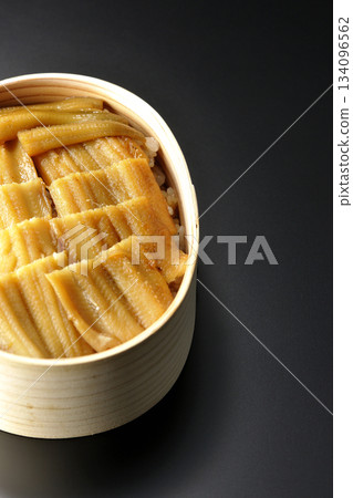 A bento box of boiled conger eel in a bento box photographed against a black background 134096562
