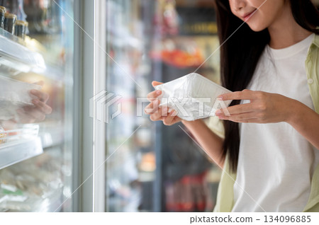 Asian woman customer looking or buying a fresh food or cooking ingredient from fridge in supermarket Asian woman customer looking or buying a fresh food or cooking ingredient from fridge in supermarket 134096885