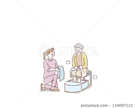 An elderly woman having a foot bath and a nurse, caregiver, or helper offering a towel An elderly woman having a foot bath and a nurse, caregiver, or helper offering a towel 134097122