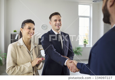 Smiling business team handshake closing deal in office meeting, partnership win Smiling business team handshake closing deal in office meeting, partnership win 134097227