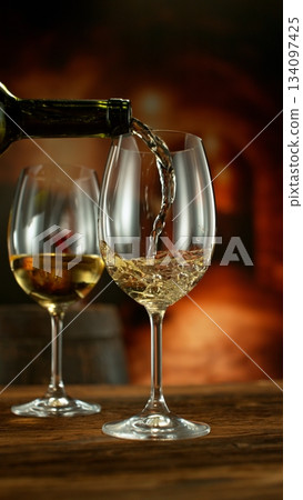 Close-up of white wine pouring into glass , old cellar environment 134097425