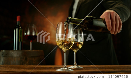 Close-up of white wine pouring into glass , old cellar environment 134097426