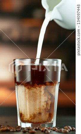 Freeze Motion Shot of Pouring Milk into Coffee in a Cafe 134097448