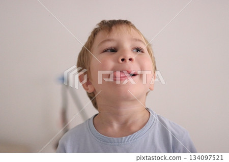 Little boy making silly face sticking out tongue 134097521