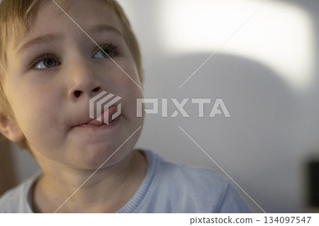 Young boy playfully sticking out tongue expressing fun 134097547