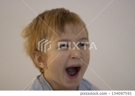 Young boy shouting with open mouth expressing emotion Young boy shouting with open mouth expressing emotion 134097591