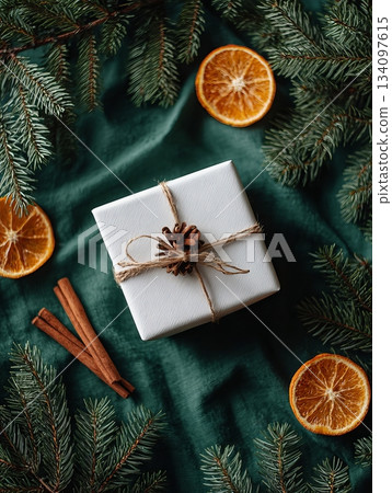 Rustic flatly Christmas Gift Box with Dried Oranges, Cinnamon Sticks, and Pine Branches on Green Fabric. Perfect for holiday gifts, seasonal promotions, and Christmas decorations. Rustic flatly Christmas Gift Box with Dried Oranges, Cinnamon Sticks, and Pine Branches on Green Fabric. Perfect for holiday gifts, seasonal promotions, and Christmas decorations. 134097615