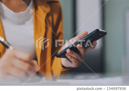 Business woman using calculator for do math finance on wooden desk in office and business working background, tax, accounting, statistics and analytic research concept. Business woman using calculator for do math finance on wooden desk in office and business working background, tax, accounting, statistics and analytic research concept. 134097936