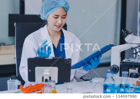 Portrait, science and happy woman on laptop in lab to research chemistry, test or innovation. Microscope, scientist and face of medical doctor in goggles for microbiology, healthcare or pharma study 134097990