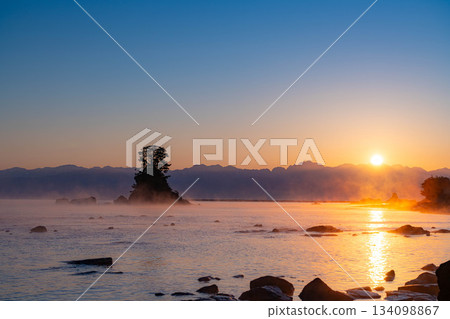 A winter tradition: A windstorm on Amaharashi Coast and the sunrise over the Ushiro-Tateyama mountain range [Toyama Prefecture] 134098867