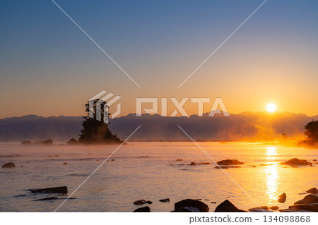 A winter tradition: A windstorm on Amaharashi Coast and the sunrise over the Ushiro-Tateyama mountain range [Toyama Prefecture] 134098868